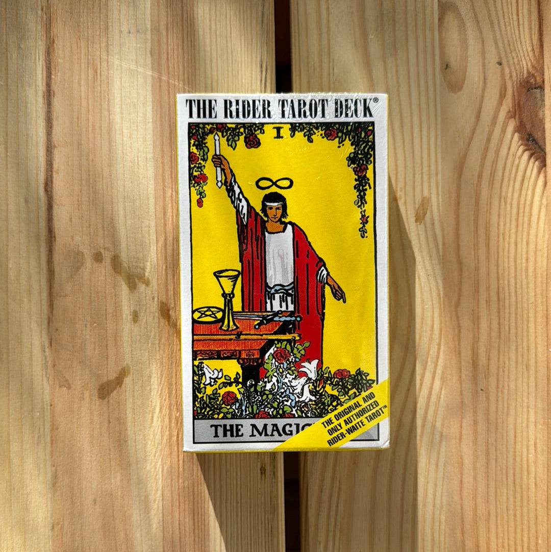 The Rider Tarot Deck by Sacred Light Soundbaths and Crystals, featuring colorful illustrated tarot cards spread out on a wooden surface.