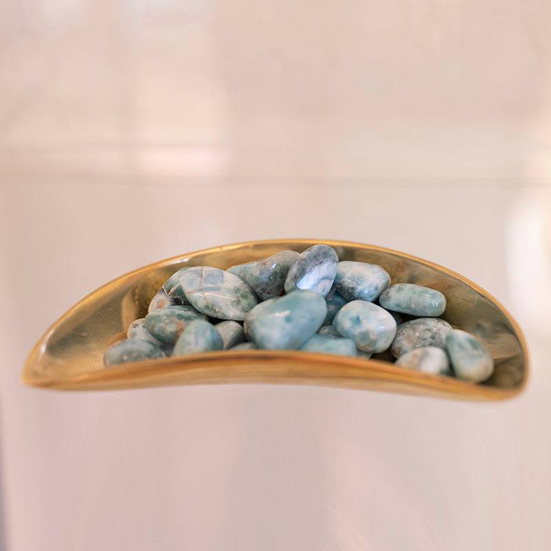 Tumbled Larimar stone from Sacred Light Soundbaths and Crystals, showcasing smooth, polished blue and white gemstone with natural patterns.