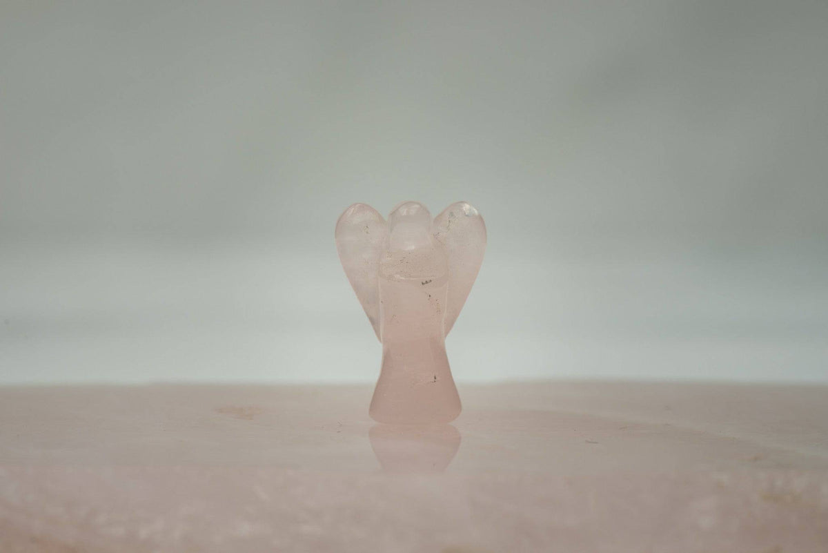 Small rose quartz pocket angel made of crystal stones, featuring delicate wings and a serene facial expression, from Sacred Light Soundbaths.