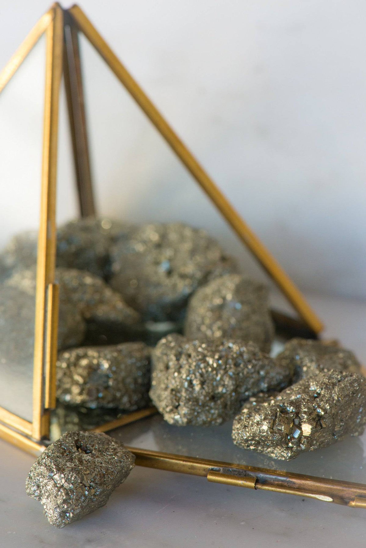 Natural pyrite stone from Sacred Light Soundbaths and Crystals, showing metallic gold color and textured mineral surface.