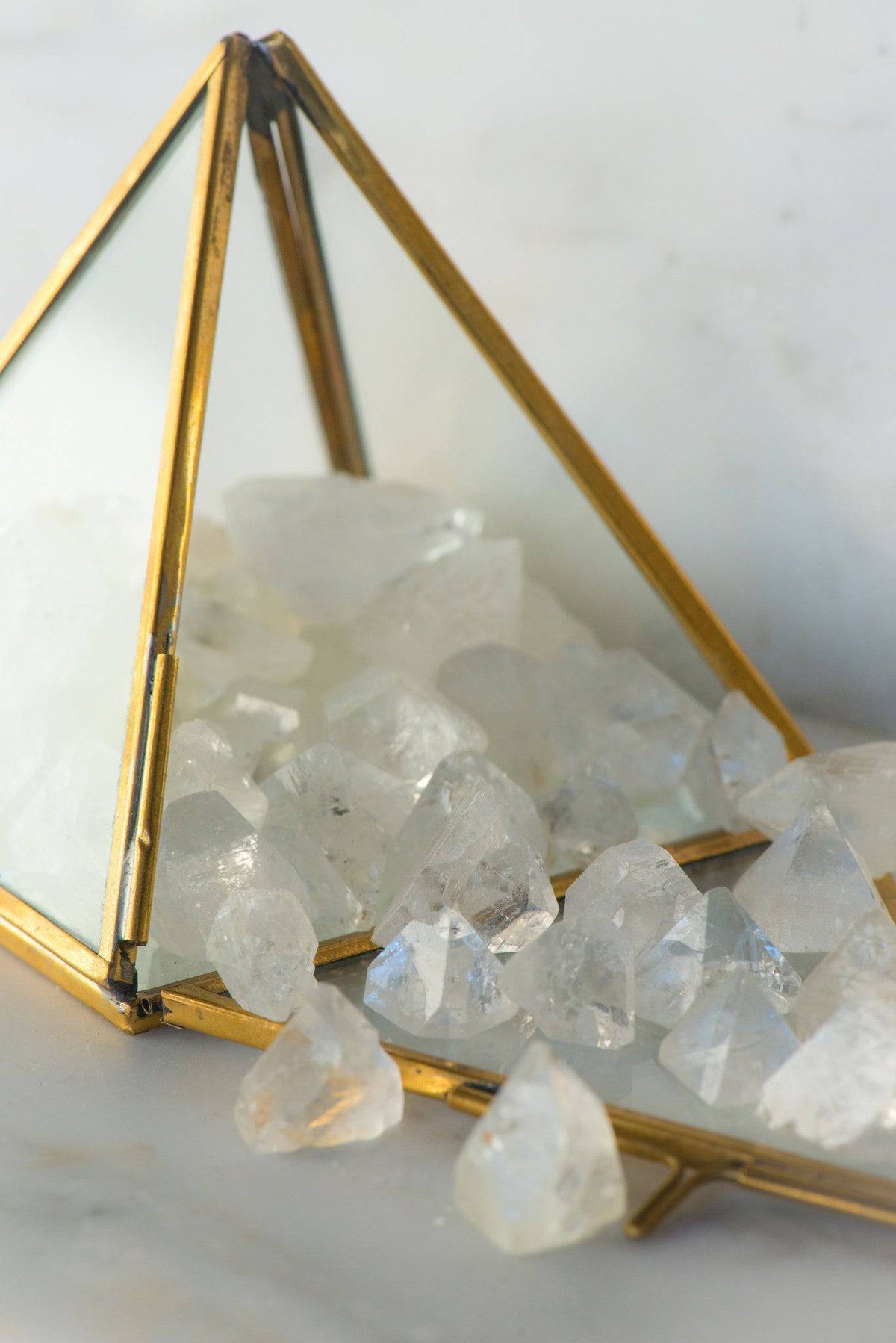 Natural Apophyllite stone from Sacred Light Soundbaths and Crystals, showcasing clear, pyramid-shaped mineral with a shimmering surface.