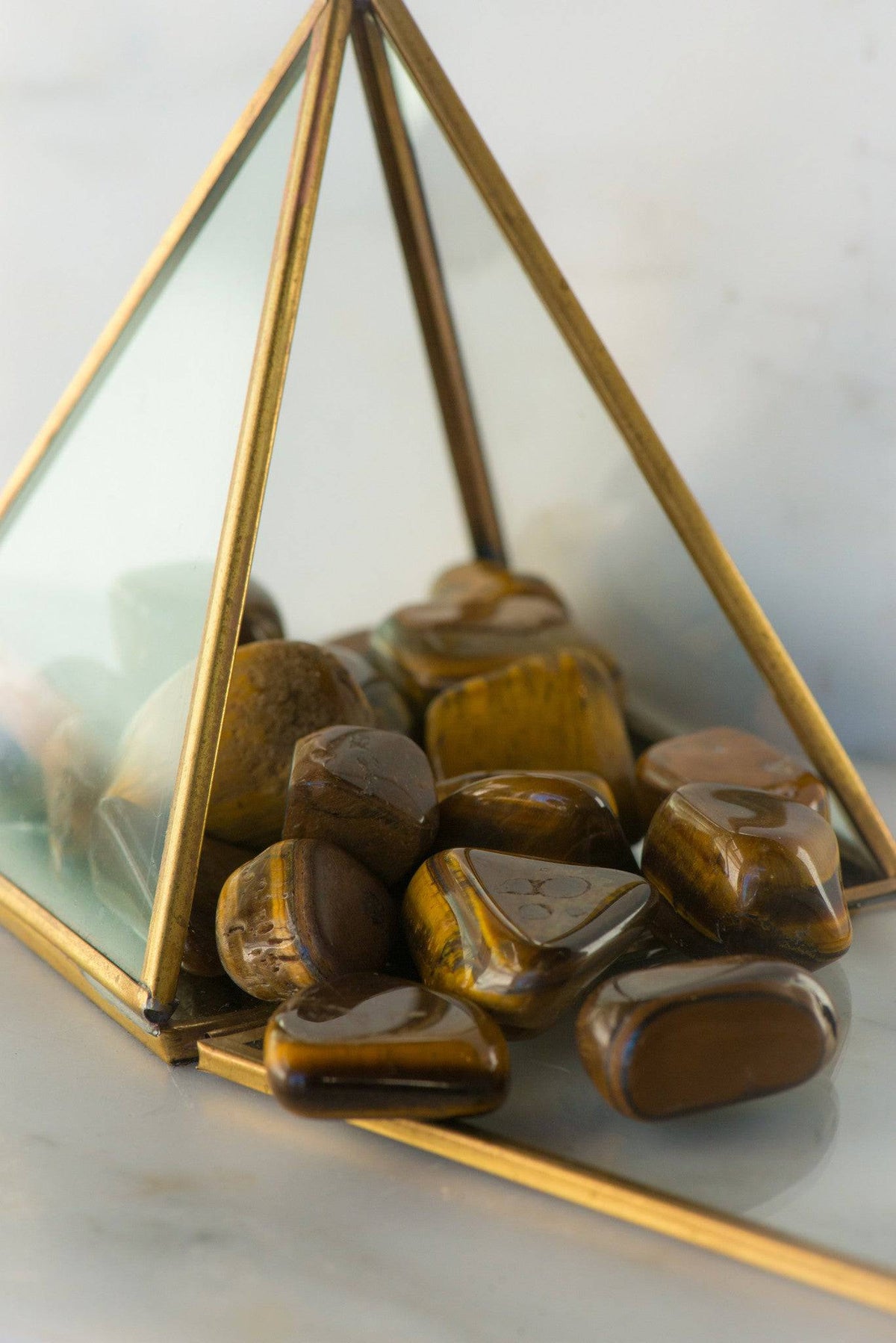 Tumbled Tiger's Eye stone from Sacred Light Soundbaths and Crystals, showcasing its smooth, polished golden-brown appearance.