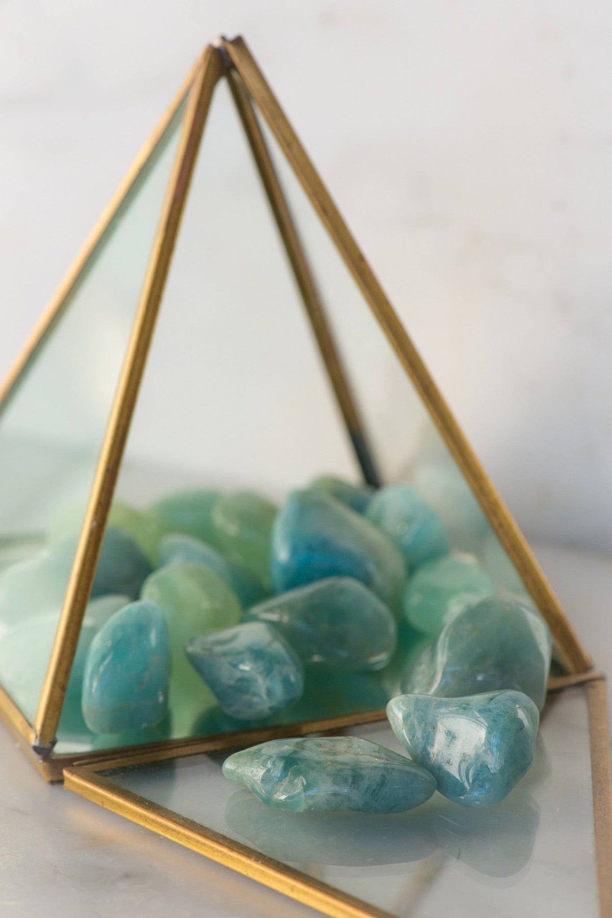 Tumbled aquamarine stone from Sacred Light Soundbaths and Crystals, smooth blue gemstone with natural variations and polished surface.