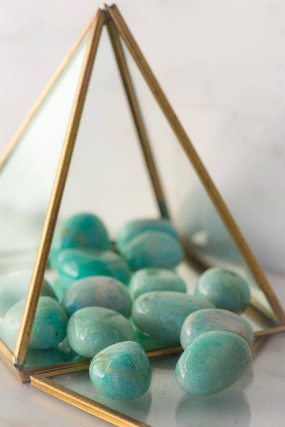 Tumbled Amazonite stones from Sacred Light Soundbaths and Crystals, showcasing smooth, polished blue-green mineral stones.