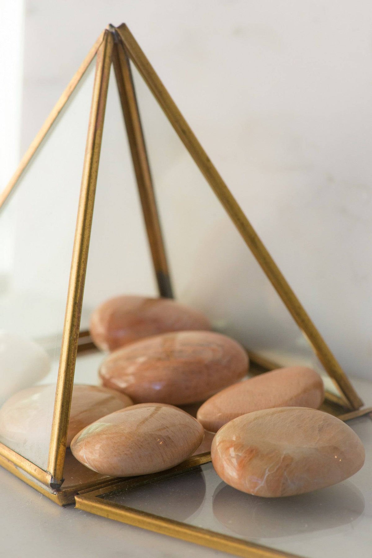 Peach Moonstone palmstone from Sacred Light Soundbaths and Crystals, smooth oval stone with soft peach and cream hues.