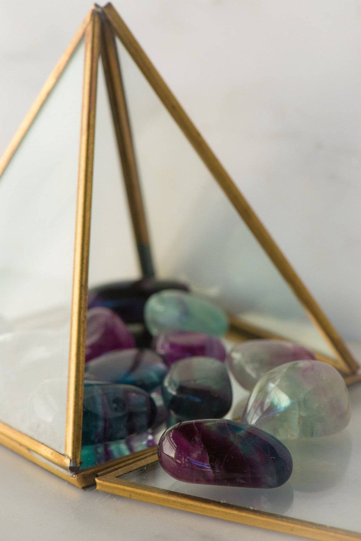 Tumbled fluorite stone from Sacred Light Soundbaths and Crystals, showing vibrant green and purple hues with smooth polished surface.