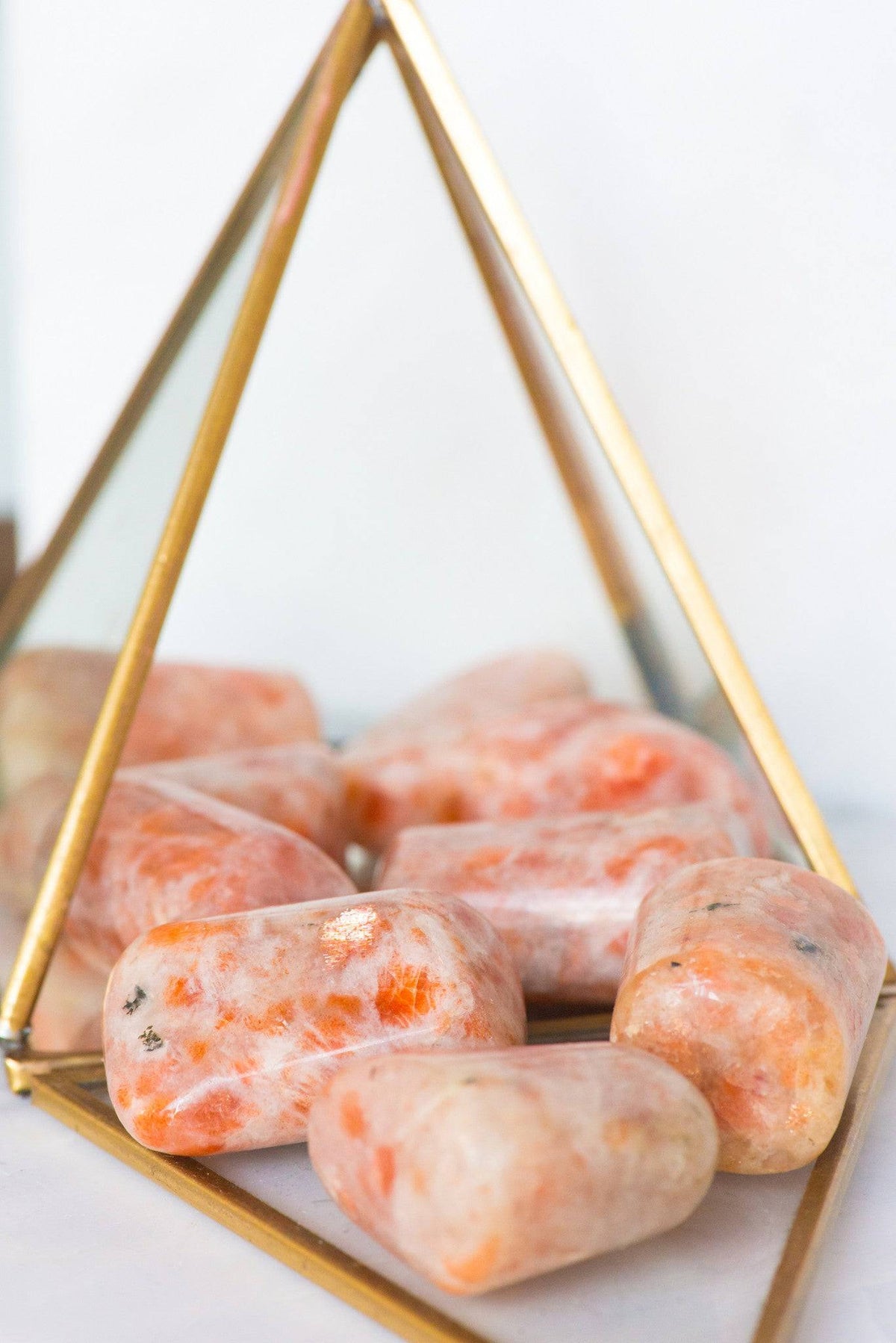 Large tumbled sunstone stone from Sacred Light Soundbaths and Crystals, showcasing its warm orange and glittering surface.