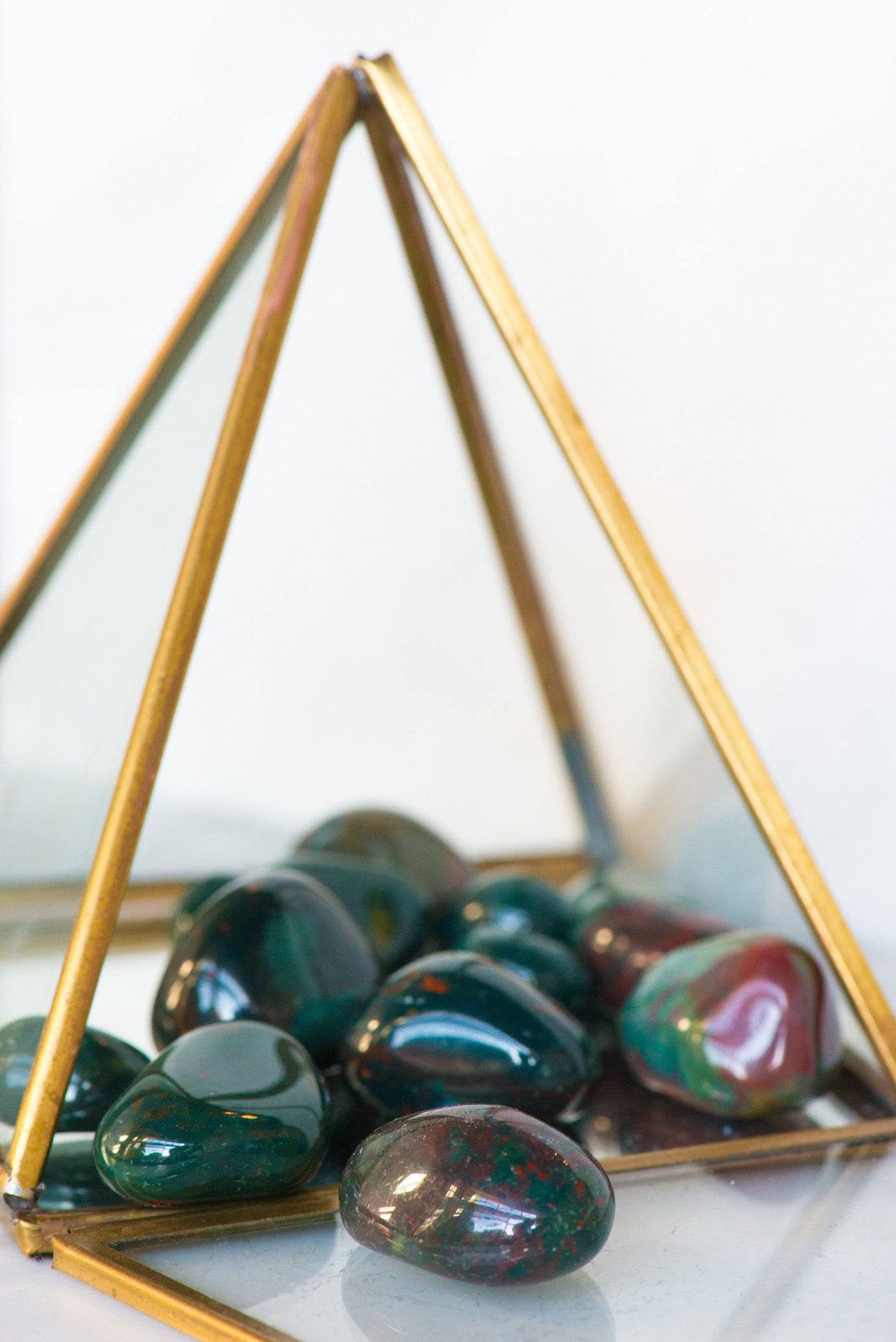 Tumbled Bloodstone stone from Sacred Light Soundbaths and Crystals, showcasing a smooth, polished dark green and red mineral.