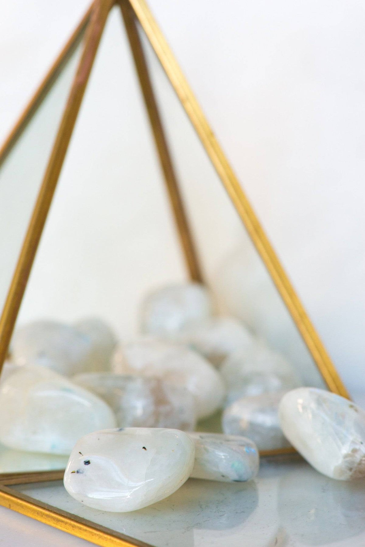Tumbled rainbow moonstone crystal stone from Sacred Light Soundbaths and Crystals, showcasing iridescent rainbow hues and smooth surface.