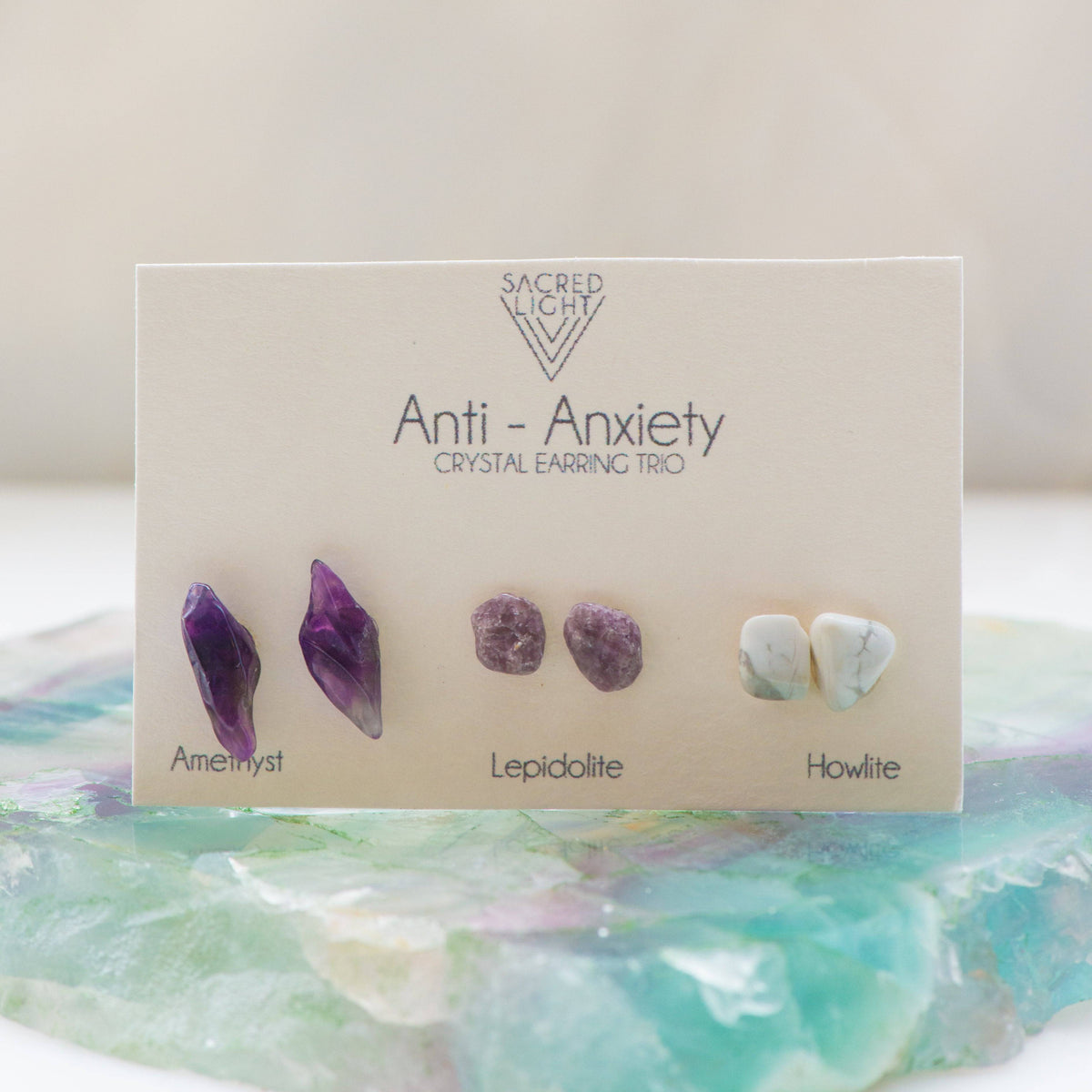 Sacred Light Soundbaths and Crystals Anti Anxiety Trio earrings featuring silver hoops with calming crystal charms on a white background.
