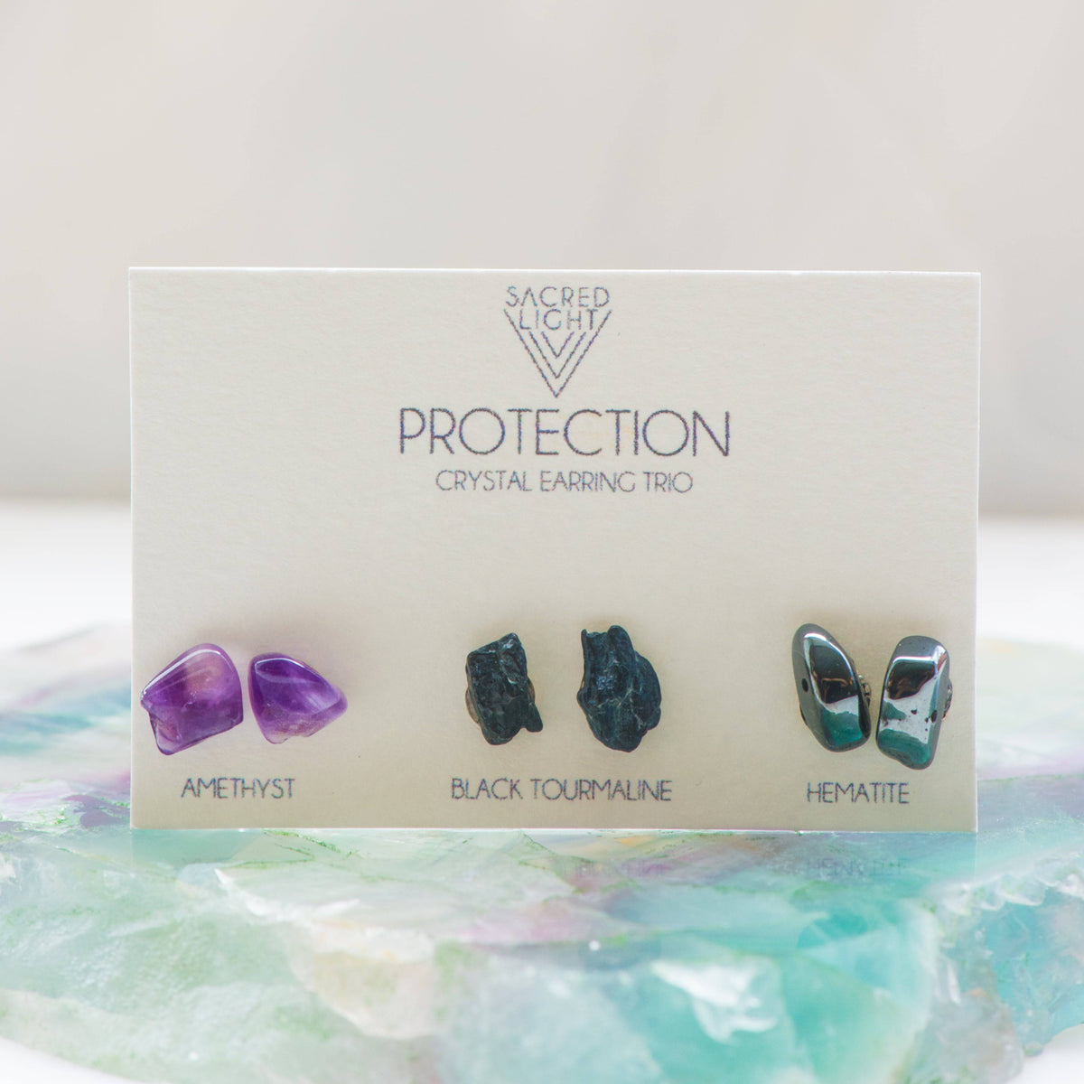 Sacred Light Soundbaths and Crystals Protection Trio Earrings with silver hooks and intricate bead and charm details.