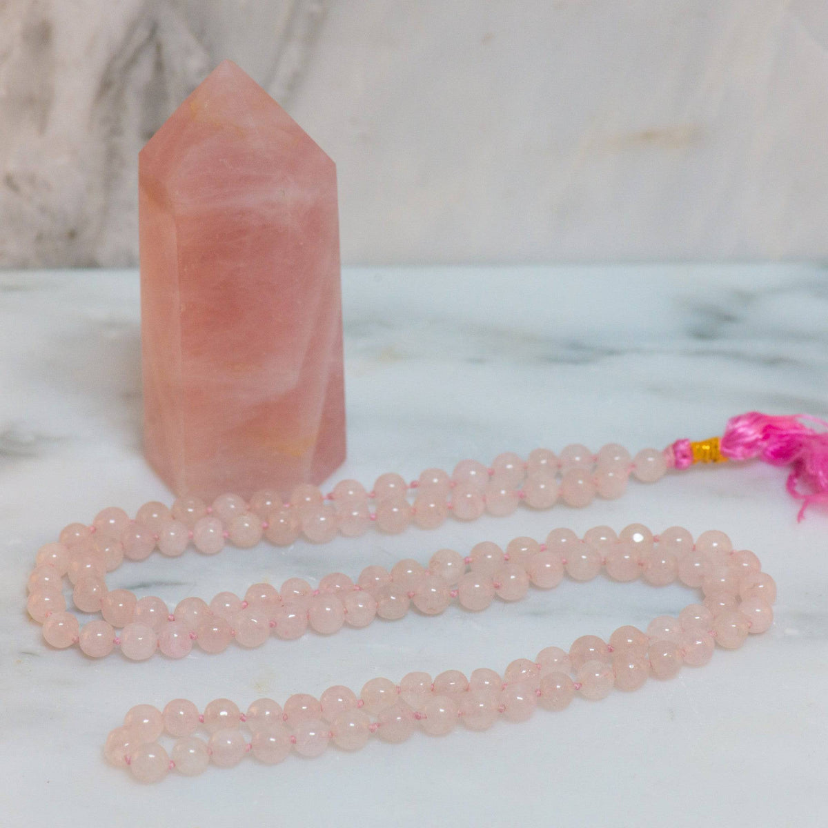 Rose Quartz Mala Necklace from Sacred Light Soundbaths and Crystals, featuring a string of pink gemstone beads and a decorative pendant.