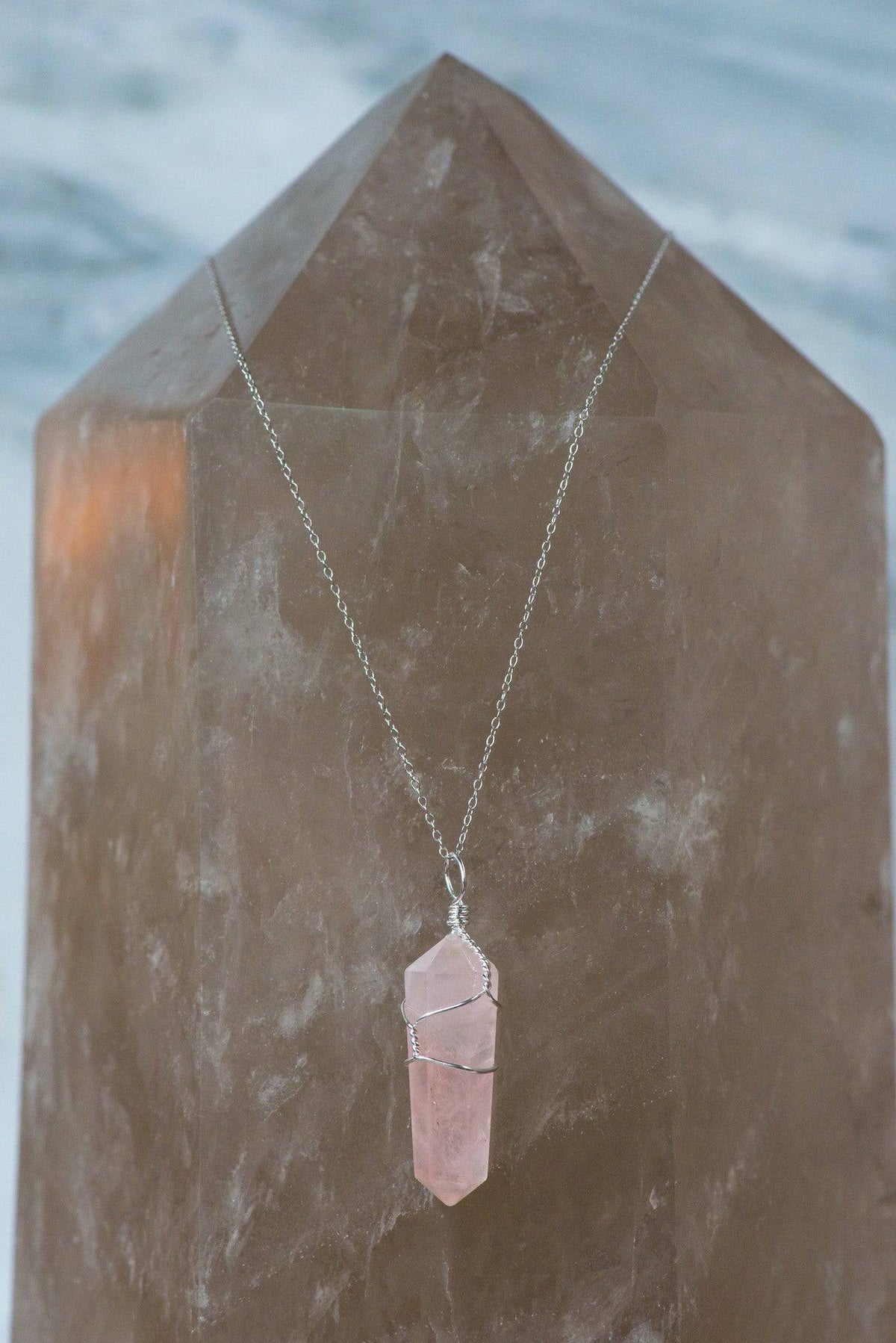 Wire wrapped rose quartz point necklace featuring a crystal pendant, crafted by Sacred Light Soundbaths and Crystals.