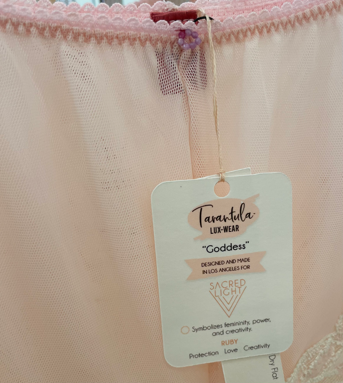 Sacred Light Goddess Cotton Candy New York lace underwear with ruby gem embellishment, featuring delicate floral design and intricate details.