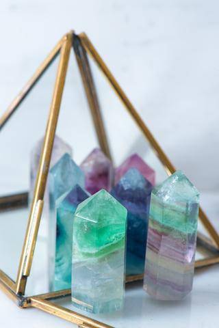 Small fluorite crystal generator from Sacred Light Soundbaths and Crystals, showcasing vibrant green and purple mineral formations.