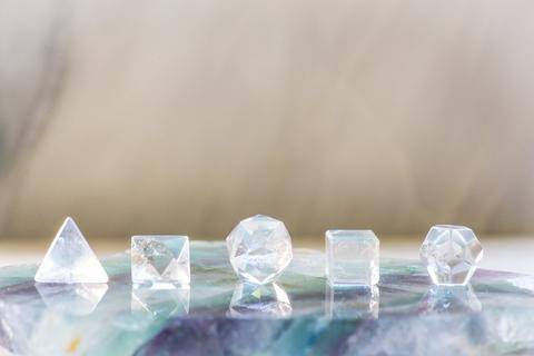 Set of five clear quartz platonic solid stones from Sacred Light Soundbaths and Crystals, showcasing geometric crystal shapes.