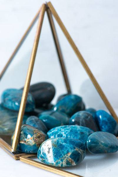 Tumbled blue apatite crystal from Sacred Light Soundbaths and Crystals showcasing its smooth, vibrant blue surface and natural stone texture.