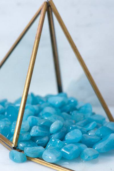 Small tumbled aquamarine crystal from Sacred Light Soundbaths and Crystals, showcasing its smooth, polished blue-green stone appearance.