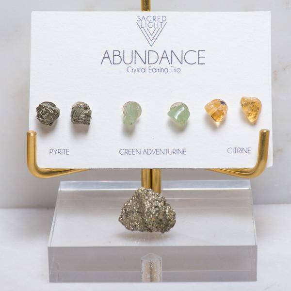 Sacred Light Soundbaths and Crystals abundance trio earrings featuring gold hoops with colorful gemstone charms and intricate designs.