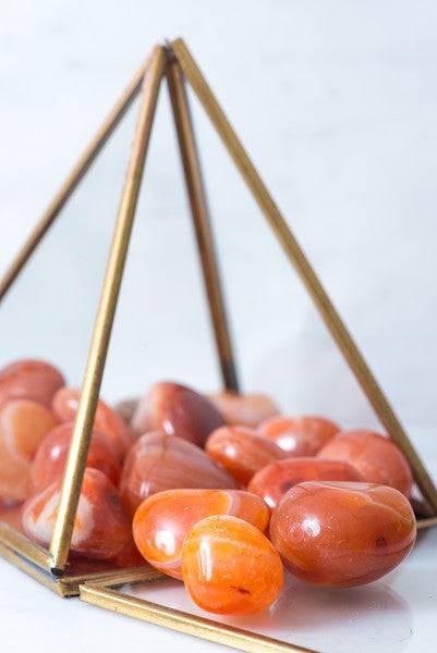 Tumbled Carnelian stone from Sacred Light Soundbaths and Crystals, showcasing its orange-brown polished surface and natural texture.