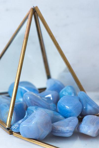 Tumbled blue lace agate crystal from Sacred Light Soundbaths and Crystals, showcasing smooth, polished blue and white banded stone.