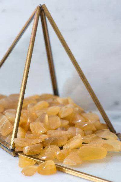 Tumbled Honey Calcite crystal from Sacred Light Soundbaths and Crystals, smooth polished stone with warm honey color.