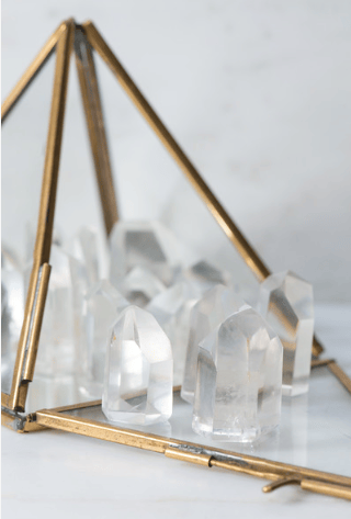 Mini clear quartz generator from Sacred Light Soundbaths and Crystals, showing a polished, transparent crystal point on a neutral background.