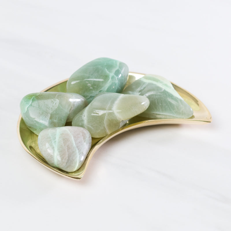 Green moonstone stone from Sacred Light Soundbaths and Crystals, smooth polished gemstone with a soft, glowing green hue.